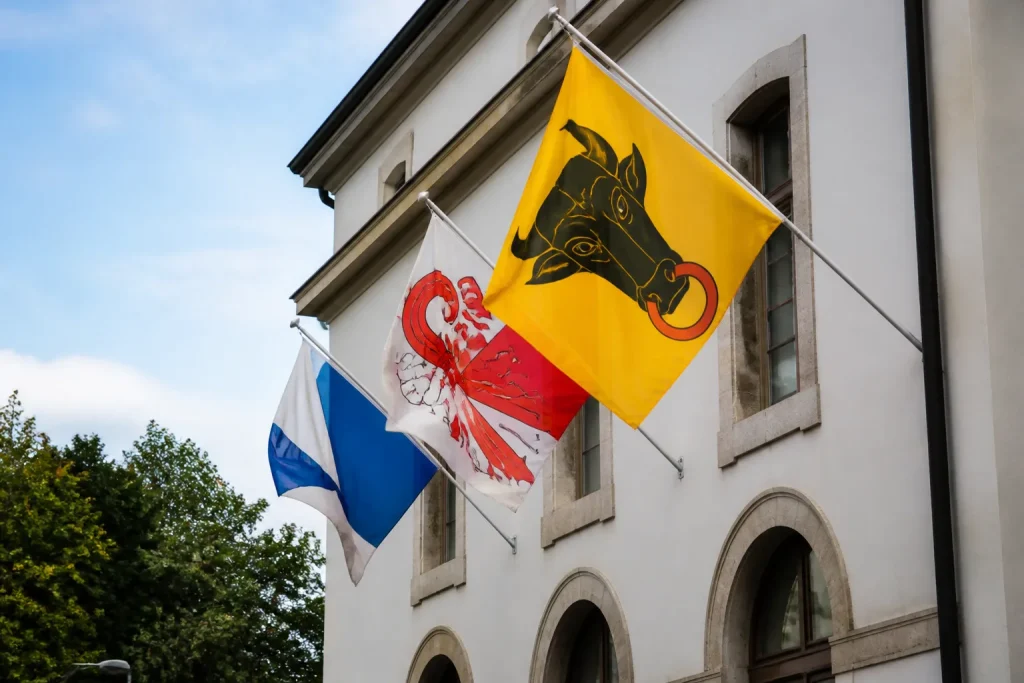 Drapeaux cantonaux colores flottant devant une mairie suisse